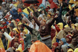 Washington Redskins fans cheer in the rain during NFL Divisional playoff game against the Atlanta Falcons, Jan. 4, 1992, at RFK Stadium in Washington, D.C. The Redskins won 24-7. (AP Photo/Doug Mills)