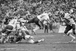Washington Redskins John Riggins (44) takes to flying as he carries the ball in NFC playoff action against the Minnesota Vikings in Washington, on Saturday, Jan. 15, 1983. Vikings John Swain (29) is on ground. (AP Photo/Ira Schwarz)