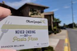 WTOP's Brandon Millman brandishes his Never Ending Pasta Pass outside the Newark, Delaware Olive Garden. (WTOP/Brandon Millman)