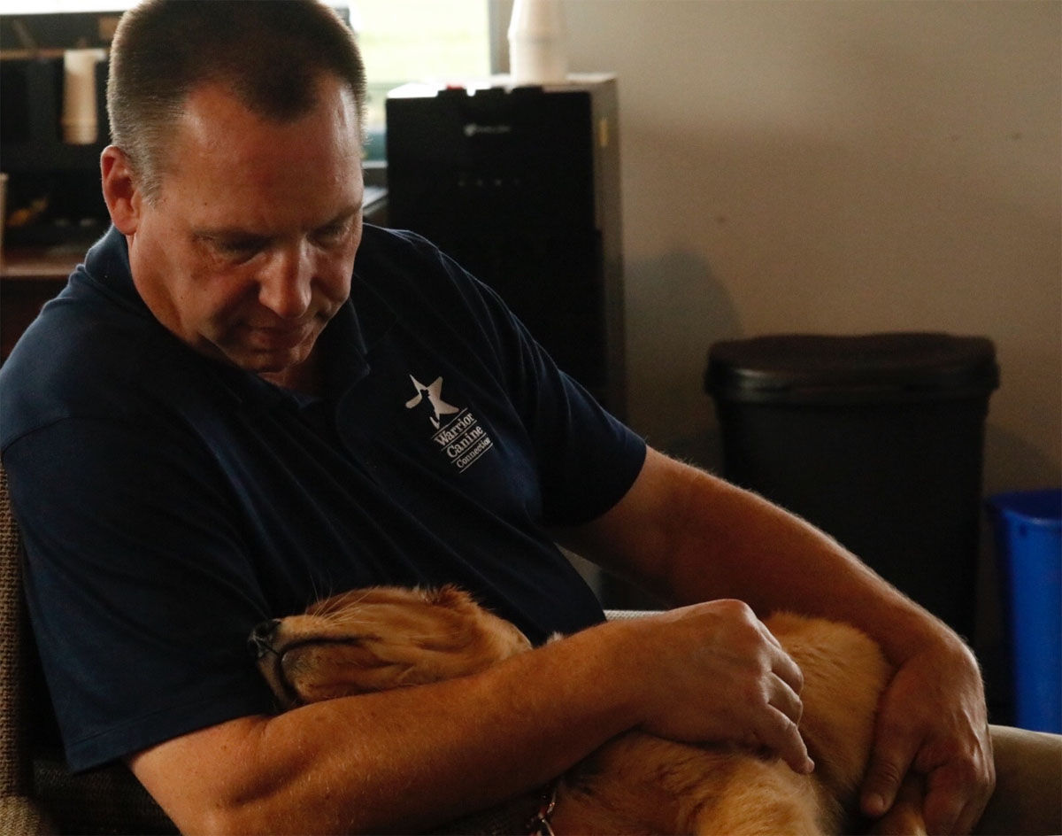 Warrior Canine Connection Executive Director Rick Young with "Lou" at the Germantown training facility. (WTOP/Kate Ryan)