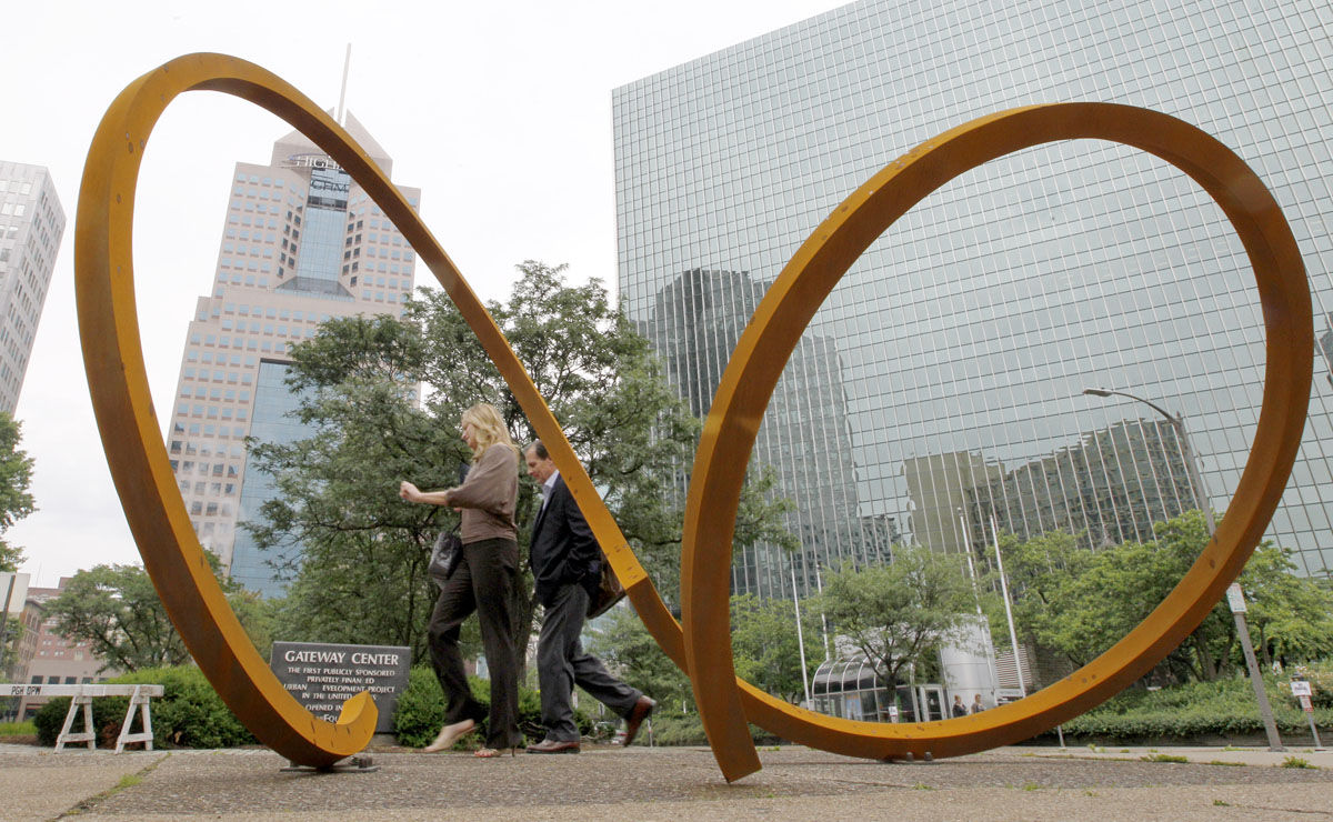 A couple of passers-by walk past the sculpture by Dee Briggs called "Two Rings - Eight Foot" installed on a median along Liberty Ave. in downtown Pittsburgh as the Three Rivers Arts Festival opens on Friday, June 1, 2012. The annual festival featuring paintings, photography, sculpture, crafts, performance and other various arts is scheduled to run through June 10, 2012. (AP Photo/Keith Srakocic)