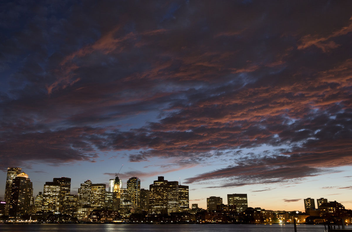 The sunset illuminates clouds over Boston harbor and the city skyline Monday, Oct. 5, 2015 in Boston. (AP Photo/Michael Dwyer)