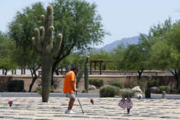 A patron visits the graves of military veterans at the National Memorial Cemetery of Arizona Friday, May 26, 2017, in Phoenix. The Memorial Day holiday is next Monday. (AP Photo/Ross D. Franklin)