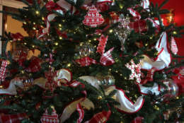 WASHINGTON, DC - NOVEMBER 27:  Ornaments are hung on a Christmas tree in the Red Room at the White House during a press preview of the 2017 holiday decorations November 27, 2017 in Washington, DC. The theme of the White House holiday decorations this year is "Time-Honored Traditions."  (Photo by Alex Wong/Getty Images)