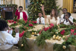 First lady Melania Trump tosses an ornament to a child across the table after he tossed one to her as she visits with children in the East Room among the 2017 holiday decorations with the theme "Time-Honored Traditions" at the White House in Washington, Monday, Nov. 27, 2017. (AP Photo/Carolyn Kaster)
