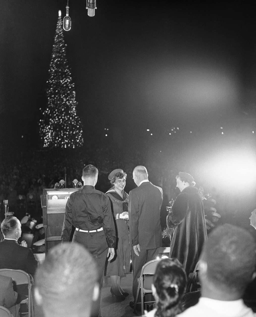 President Dwight Eisenhower shakes hands with Elizabeth Lamphere, 17-year-old girl scout, after lighting the National Christmas Tree in the park behind the White House, Dec. 23, 1958 in Washington.  First lady Mamie Eisenhower is at right.  Robert Elder, 16-year-old Arlington, Va., Boy Scout, is at left.  (AP Photo/Bob Schutz)