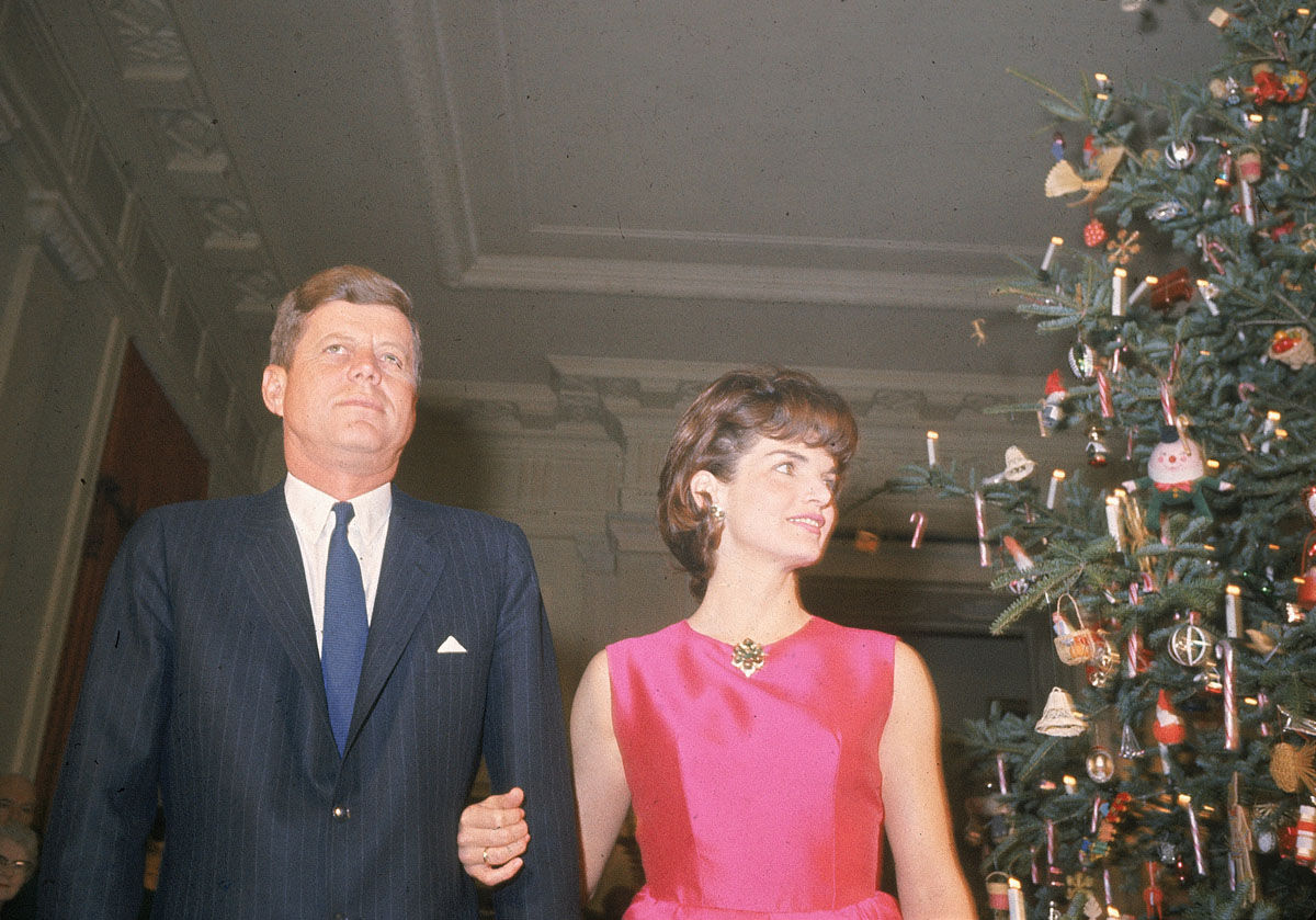 U.S. President John F. Kennedy and his wife Jacqueline Kennedy stand by the Christmas tree in the main entrance hall of the White House during a party for the staff of the Executive Mansion in Washington D.C. on Dec. 12, 1962.  (AP Photo)
