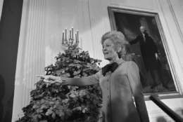 First lady Pat Nixon, wife of President Richard Nixon, talks to reporters about the Christmas decorations that now adorn the White House, in Washington, D.C., Dec. 14, 1971. Incidentally, Mrs. Nixon and the painting of George Washington behind her, are both gesturing in the same direction. (AP Photo/Bob Daugherty)
