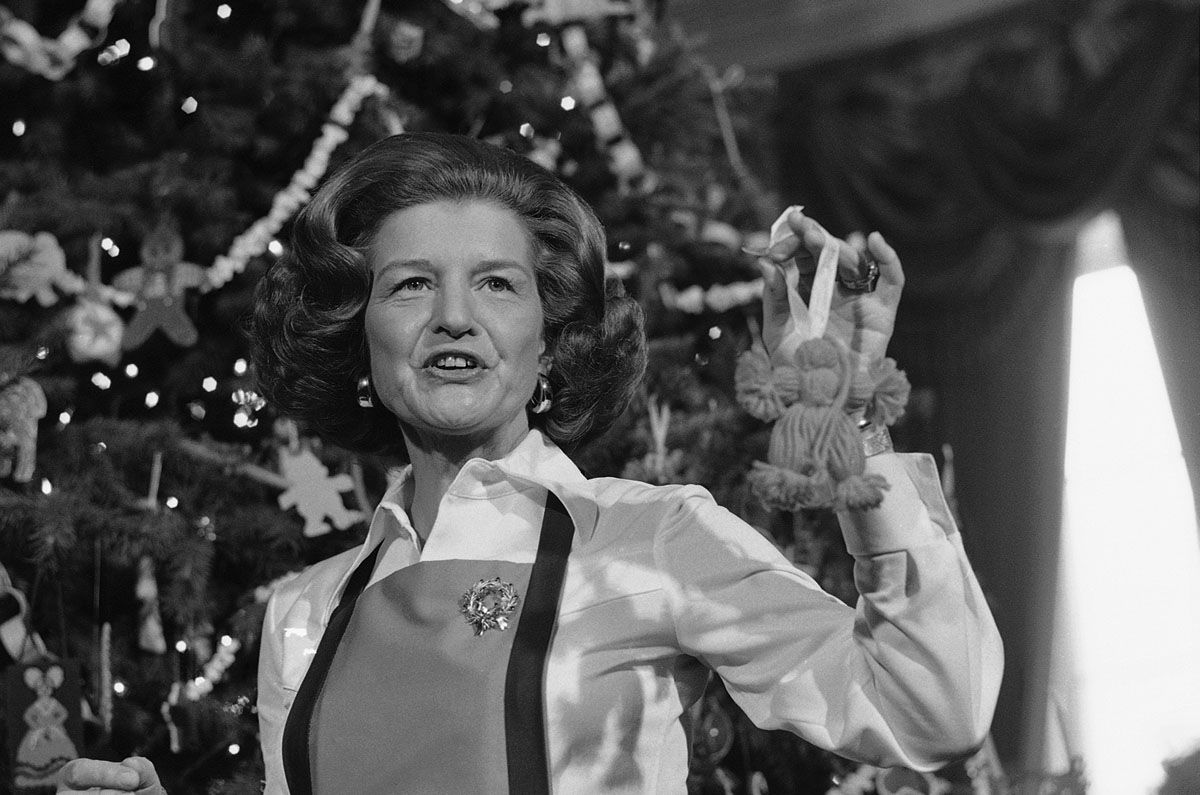 First lady Betty Ford poses with an ornament in front of the White House Christmas Tree on Monday, Dec. 15, 1975 in Washington at  the executive mansion. About 3,000 handcrafted ornaments with adorn this year's tree. (AP Photo/Bob Daugherty)