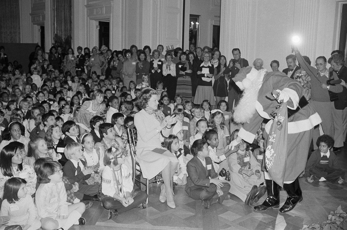First Lady Betty Ford applauds as Santa Claus greets some of the children of diplomats during a Christmas party in the White House East Room in Washington Tuesday, Dec. 16, 1975. Approximately 500 children from 84 different countries attended the party hosted by Mrs. Ford. (AP Photo/PBR/Peter Bregg)