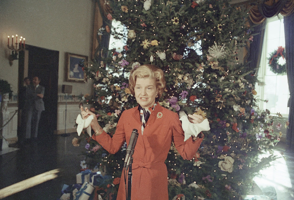First lady  Betty Ford poses in front of the White House Christmas tree in Washington on Dec. 9, 1976. (AP Photo/Charles Tasnadi)