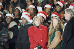 President Bill Clinton and first lady Hillary Rodham Clinton, along with daughter Chelsea, join the choir during ceremonies to light the National Christmas Tree on the Ellipse in Washington, Dec. 9, 1993. (AP Photo/Joe Marquette)