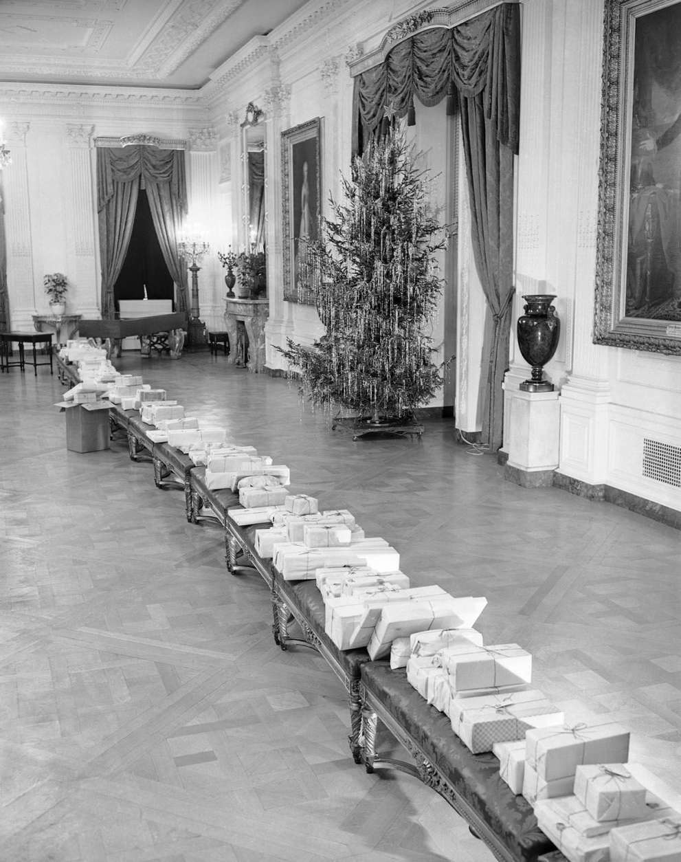 These packages, placed on benches in the East Room of the White House in Washington on Dec. 23, 1942, will be distributed by President and Mrs. Franklin Roosevelt to younger children of White House employees on Christmas Eve. The gifts all will go to children under 12. (AP Photo/George R. Skadding)
