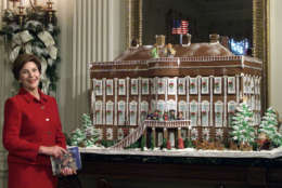 First lady Laura Bush shows off the White House gingerbread house, a replica of the White House in the 1800s as she gave members of the media a tour of the White House Christmas decorations, Monday, Dec. 3, 2001, in the State Dining room. This year's theme is "Home for the Holidays." Heightened security after the terrorist attacks will keep the White House and its lavish holiday decorations closed to all but invited VIPs. Mrs. Bush is instead taping a video tour of all the glitter to be shown at the nearby White House Visitors Center. (AP Photo/Ron Edmonds)