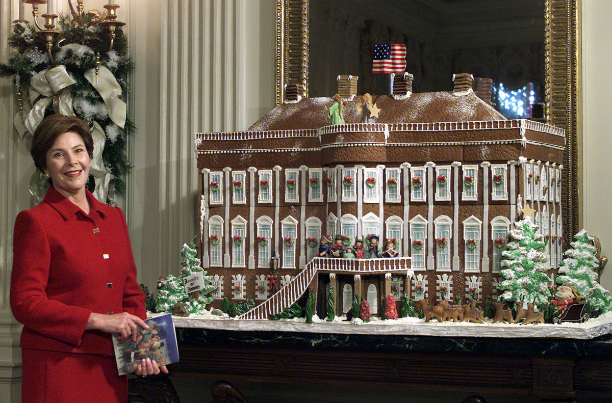 First lady Laura Bush shows off the White House gingerbread house, a replica of the White House in the 1800s as she gave members of the media a tour of the White House Christmas decorations, Monday, Dec. 3, 2001, in the State Dining room. This year's theme is "Home for the Holidays." Heightened security after the terrorist attacks will keep the White House and its lavish holiday decorations closed to all but invited VIPs. Mrs. Bush is instead taping a video tour of all the glitter to be shown at the nearby White House Visitors Center. (AP Photo/Ron Edmonds)