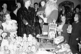 Mrs. Eleanor Roosevelt was on hand to see the Santa Claus at the Kiwanis Club in Arlington, Va., on Dec. 24, 1942, and to hand out presents to 375 children like this little fellow getting the truck. Her usual Christmas Eve day tour was somewhat curtailed by the reduced number of underprivileged and the resulting elimination of some of the parties. (AP Photo/Robert Clover)