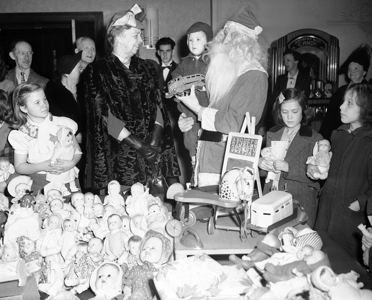 Mrs. Eleanor Roosevelt was on hand to see the Santa Claus at the Kiwanis Club in Arlington, Va., on Dec. 24, 1942, and to hand out presents to 375 children like this little fellow getting the truck. Her usual Christmas Eve day tour was somewhat curtailed by the reduced number of underprivileged and the resulting elimination of some of the parties. (AP Photo/Robert Clover)