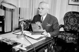 Seated in the parlor of his home at Independence, Mo., U.S. President Harry Truman presses remote control button which turned on the lights of a large Christmas tree set up on the lawn of the White House, Dec. 24, 1948. (AP Photo/Bill Chaplis)