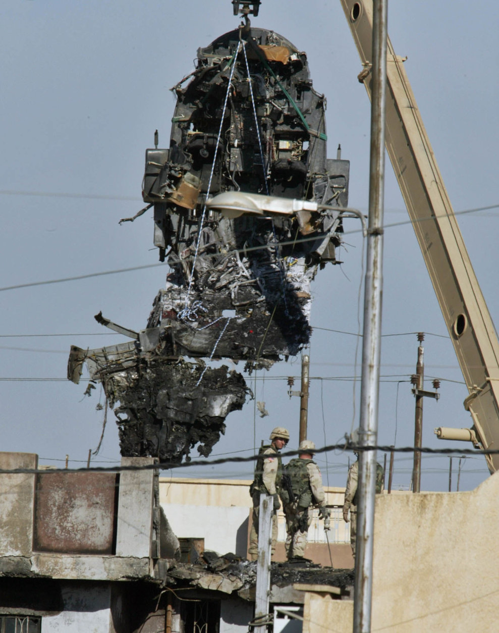 US Army soldiers remove the wreckage of an U.S. Army Black Hawk helicopter, Sunday, Nov 16, 2003 after it crashed into a residential area in Mosul, northern Iraq, late Saturday.  A military spokesman said that the  two helicopters which crashed belonged to the 101st Airborne Division, which controls northern Iraq and that the reasons were not yet clear. At least 17 US Army soldiers where killed. (AP Photo/Anja Niedringhaus)