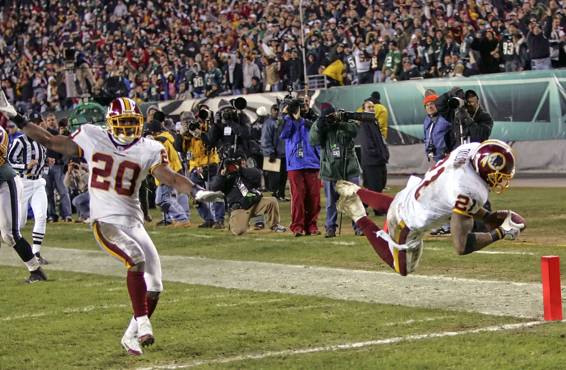 Washington Redskins safety Sean Taylor (21) leaps for a touchdown after his 39-yard fumble-return against the Philadelphia Eagles in the fourth quarter of their NFL football game Sunday, Jan. 1, 2006, in Philadelphia. At left is safety Pierson Prioleau (20). The Redskins won, 31-20. (AP Photo/Tom Mihalek)