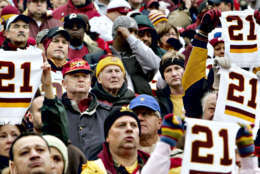 Solemn football fans hold up towels with number 21 in memory of slain Washington Redskins safety Sean Taylor during a ceremony before the start of the football game against the Buffalo Bills Sunday, Dec. 2, 2007, at FedExField in Landover, Md. (AP Photo/J. Scott Applewhite)