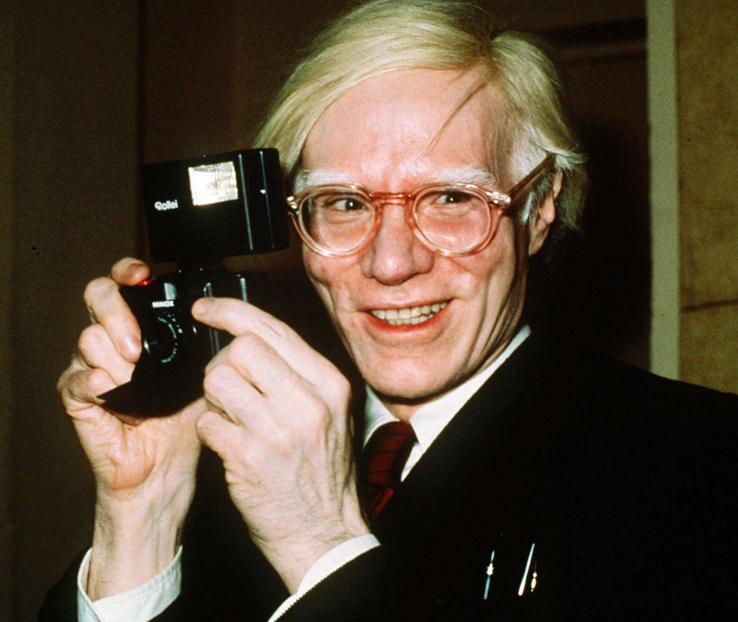 FILE - In this 1976 file photo, pop artist Andy Warhol smiles in New York. In the late 1970s, pop artist Andy Warhol and writer Truman Capote recorded dozens of hours of intimate conversations they planned to use as the basis for a Broadway play however, the two icons moved on to other projects, the tapes were forgotten and both men died. Director Rob Roth tracked down the tapes and adapted them for the play premiering Sunday, Sept. 10, 2017, in Cambridge, Mass. (AP Photo/Richard Drew, File)