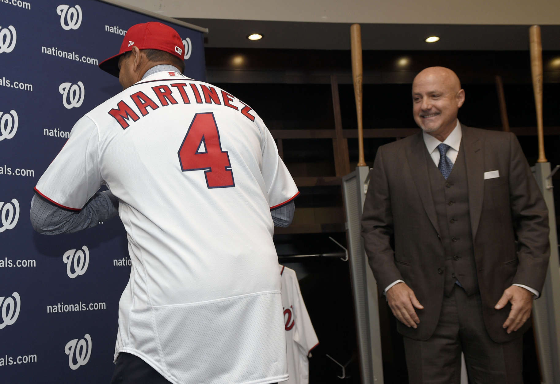 Washington Nationals new manager Dave Martinez, left, shows off his jersey as general manager Mike Rizzo, right, watches during a baseball press conference, Thursday, Nov. 2, 2017, in Washington. (AP Photo/Nick Wass)