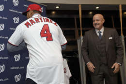 Washington Nationals new manager Dave Martinez, left, shows off his jersey as general manager Mike Rizzo, right, watches during a baseball press conference, Thursday, Nov. 2, 2017, in Washington. (AP Photo/Nick Wass)