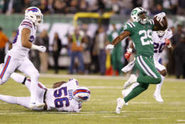 New York Jets running back Bilal Powell, right, avoids being tripped up by Buffalo Bills defensive end Ryan Davis (56) on a long run during the second half of an NFL football game, Thursday, Nov. 2, 2017, in East Rutherford, N.J. (AP Photo/Kathy Willens)