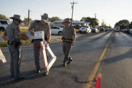Texas state troopers erect a barricade to control traffic near the First Baptist Church of Sutherland Springs after a fatal shooting, Sunday, Nov. 5, 2017, in Sutherland Springs, Texas. A man opened fire inside of the church in the small South Texas community on Sunday, killing more than 20 people. (AP Photo/Darren Abate)