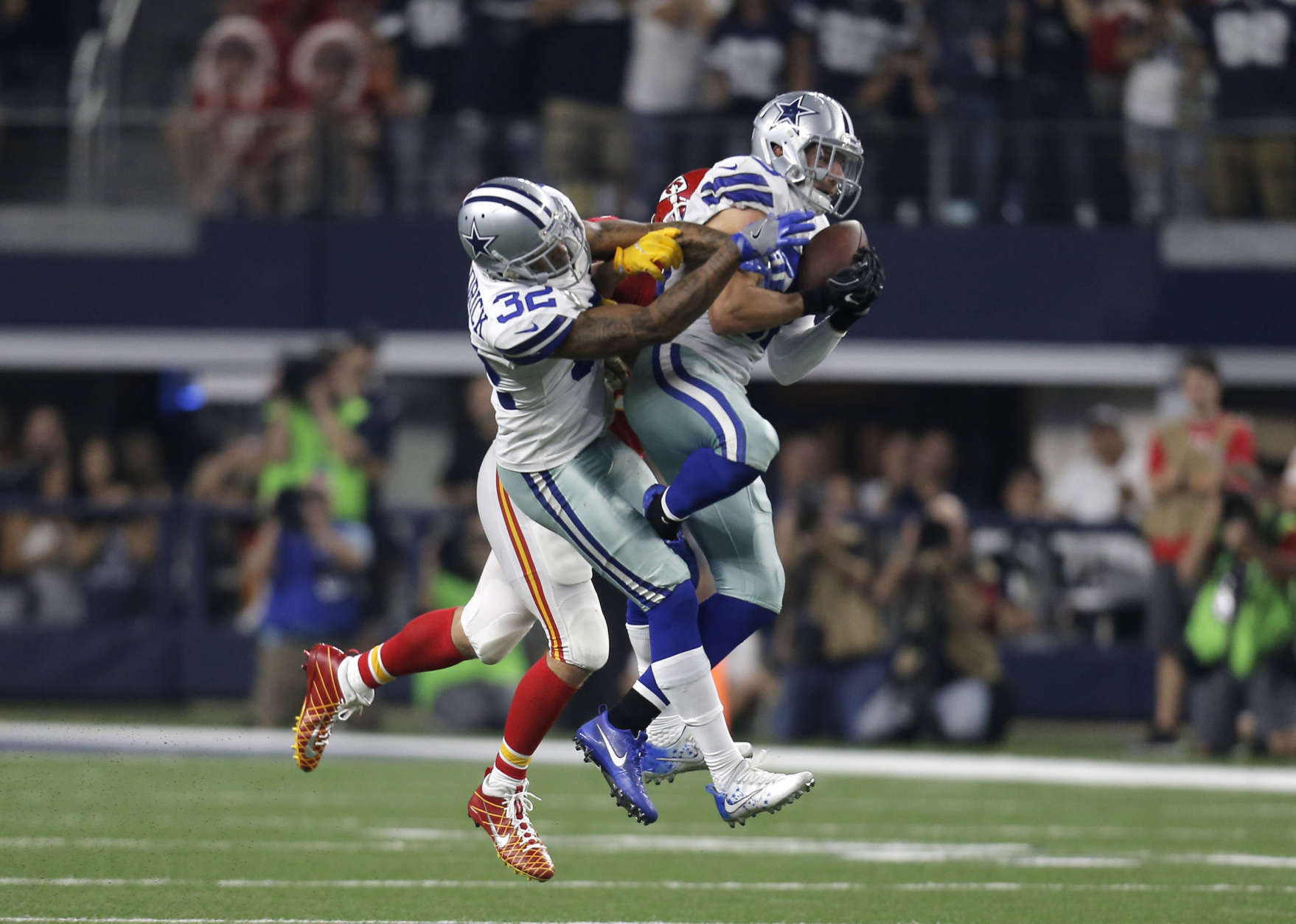 Dallas Cowboys safety Jeff Heath (38) intercepts a pass in front of Orlando Scandrick (32) intended for Kansas City Chiefs tight end Travis Kelce, rear, in the second half of an NFL football game, Sunday, Nov. 5, 2017, in Arlington, Texas. (AP Photo/Brandon Wade)