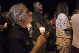 Texas Gov. Greg Abbott participates in a candlelight vigil for the victims of a fatal shooting at the First Baptist Church in Sutherland Springs, Sunday, Nov. 5, 2017, in Sutherland Springs, Texas. A man opened fire inside of the church in the small South Texas community on Sunday, killing more than 20 people. (AP Photo/Darren Abate)