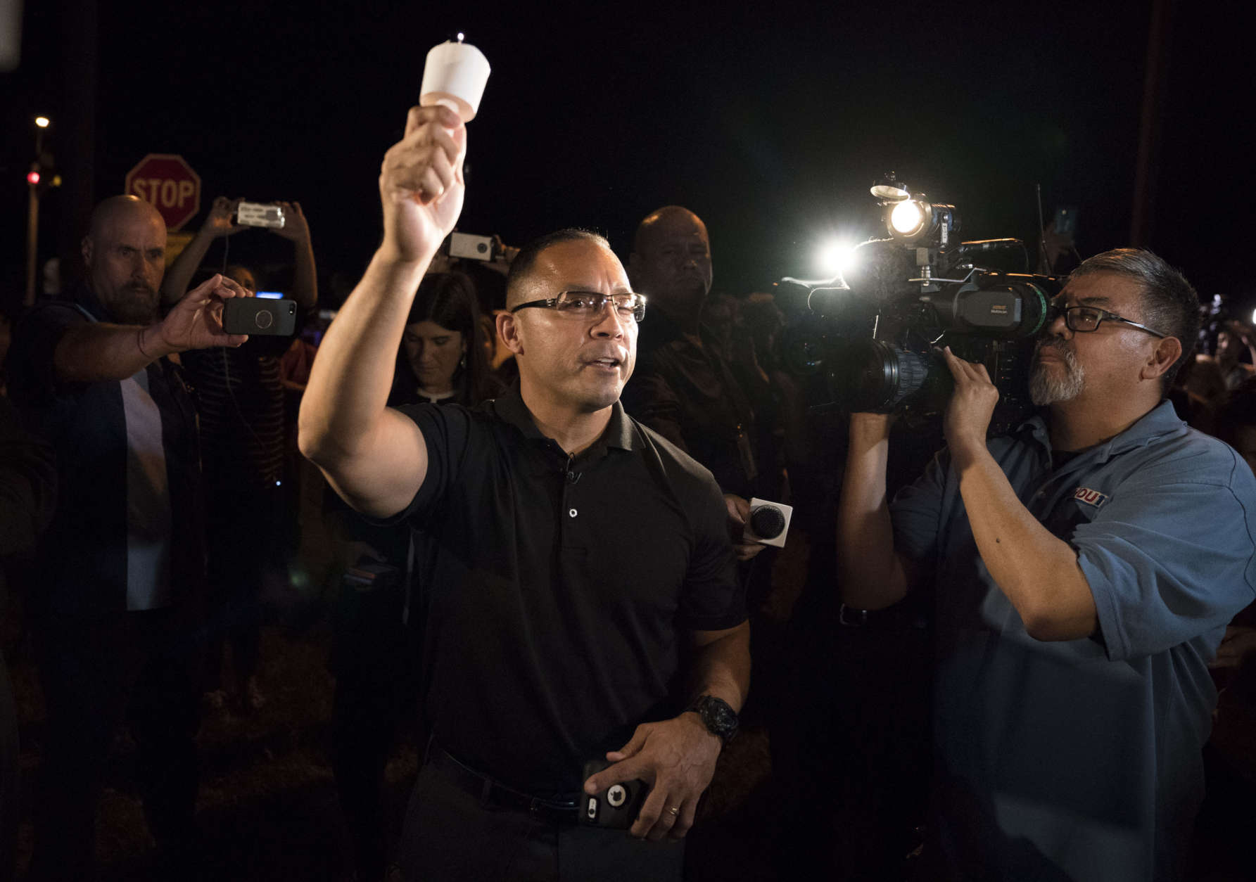 Community leader Mike Gonzales leads a candlelight vigil for the victims of a fatal shooting at the First Baptist Church of Sutherland Springs, Sunday, Nov. 5, 2017, in Sutherland Springs, Texas. (AP Photo/Darren Abate)