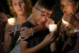 Mona Rodriguez, Jayanthony Hernandez, 12 and Juanita Rodriguez, from left, participate in a candlelight vigil held for the victims of a fatal shooting at the First Baptist Church of Sutherland Springs, Sunday, Nov. 5, 2017, in Sutherland Springs, Texas. (AP Photo/Laura Skelding)