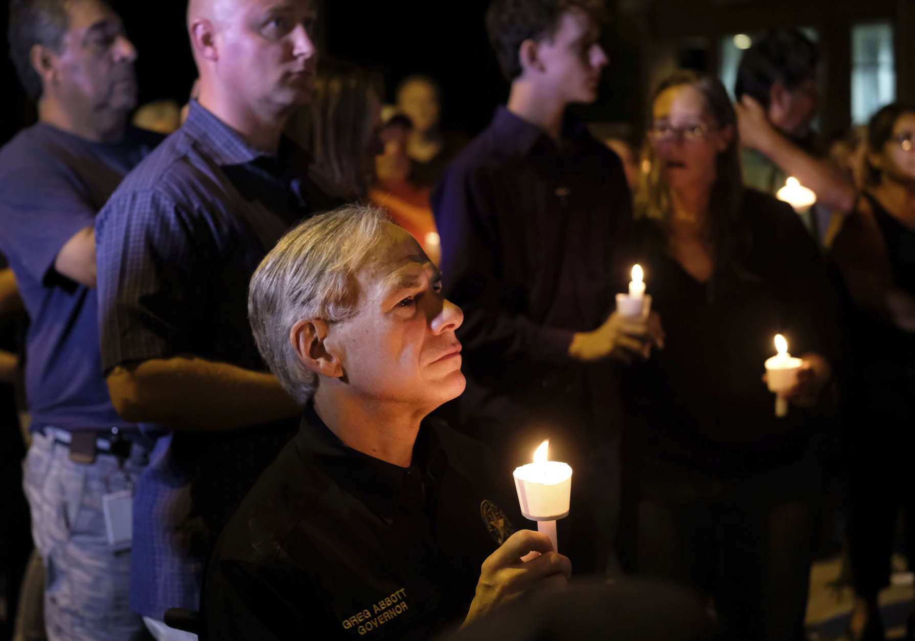 Texas Gov. Greg Abbott attends a candlelight vigil held for the victims of a fatal shooting at the First Baptist Church of Sutherland Springs, Sunday, Nov. 5, 2017, in Sutherland Springs, Texas. (AP Photo/Laura Skelding)