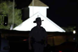 A law enforcement official walks past the First Baptist Church of Sutherland Springs, the scene of a mass shooting, Sunday, Nov. 5, 2017, in Sutherland Springs, Texas. (AP Photo/Eric Gay)