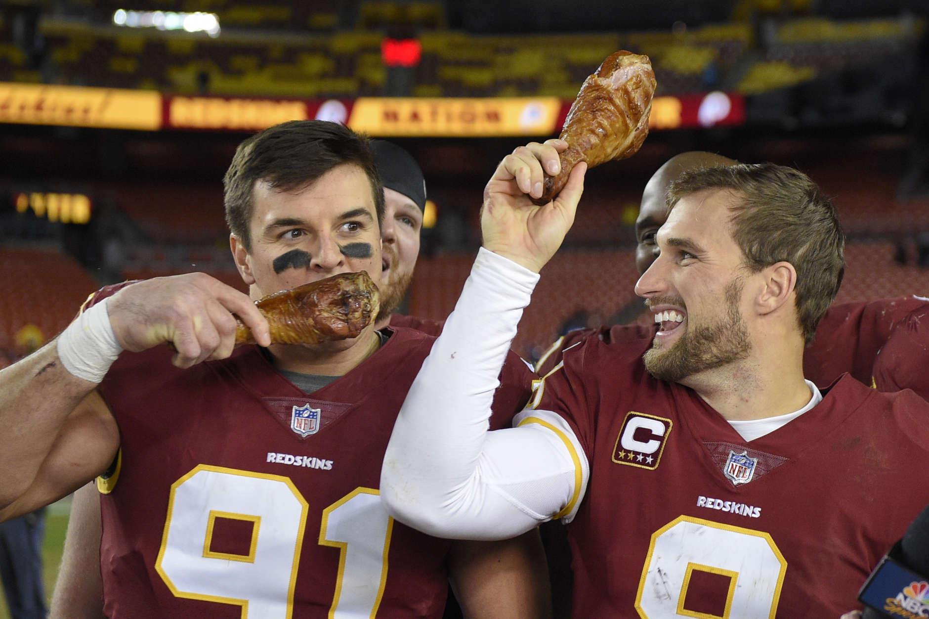 Washington Redskins quarterback Kirk Cousins (8) holds up a turkey leg as outside linebacker Ryan Kerrigan (91) eats his after an NFL football game against the New York Giants in Landover, Md., Friday, Nov. 24, 2017. The Redskins defeated the Giants 20-10. (AP Photo/Nick Wass)
