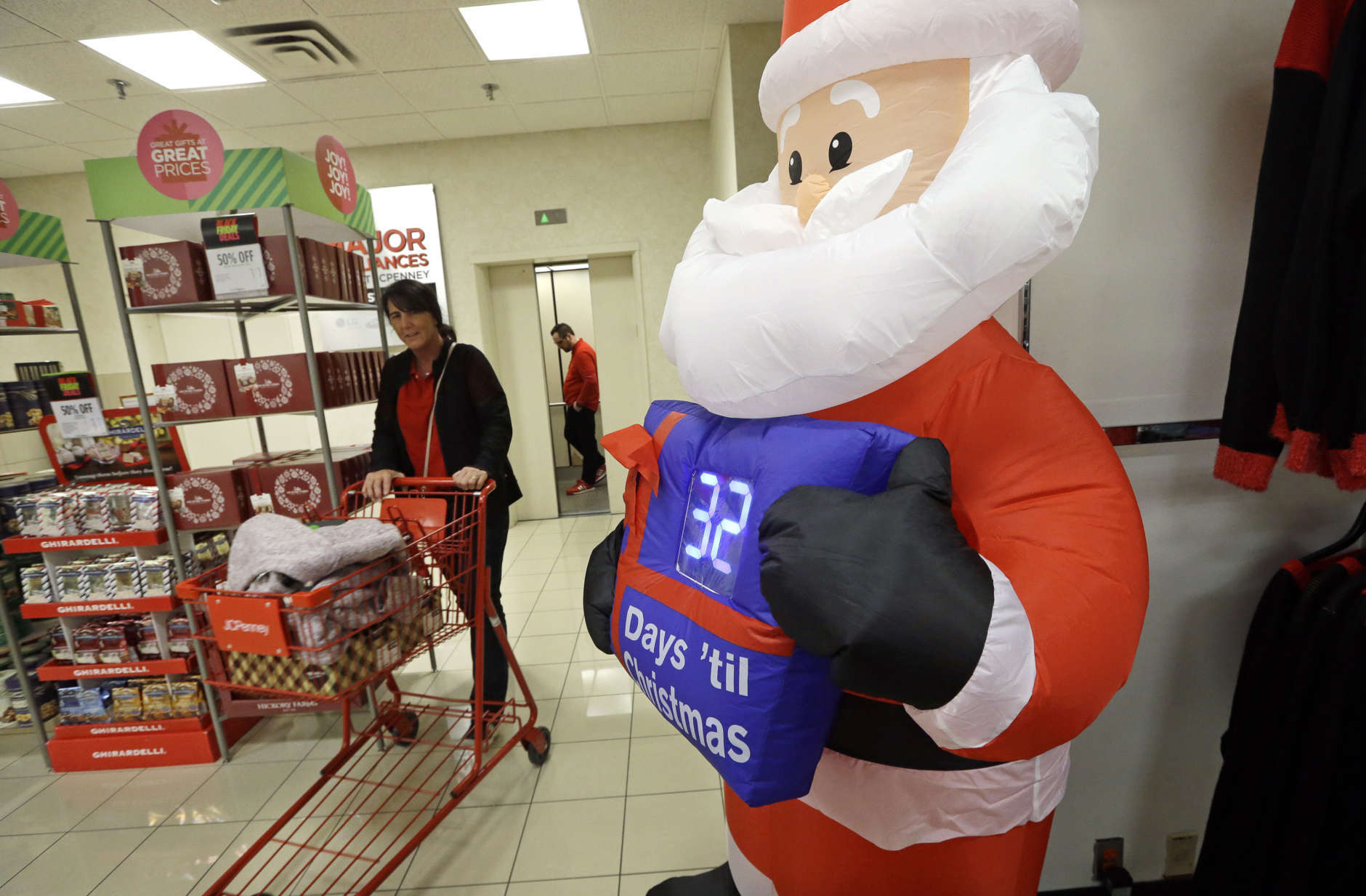 A shopper rolls a full cart past a Santa figure with a countdown clock numbering the days until Christmas at a J.C. Penney store, Friday, Nov. 24, 2017, in Seattle. Black Friday has morphed from a single day when people got up early to score doorbusters into a whole season of deals, so shoppers may feel less need to be out. (AP Photo/Elaine Thompson)