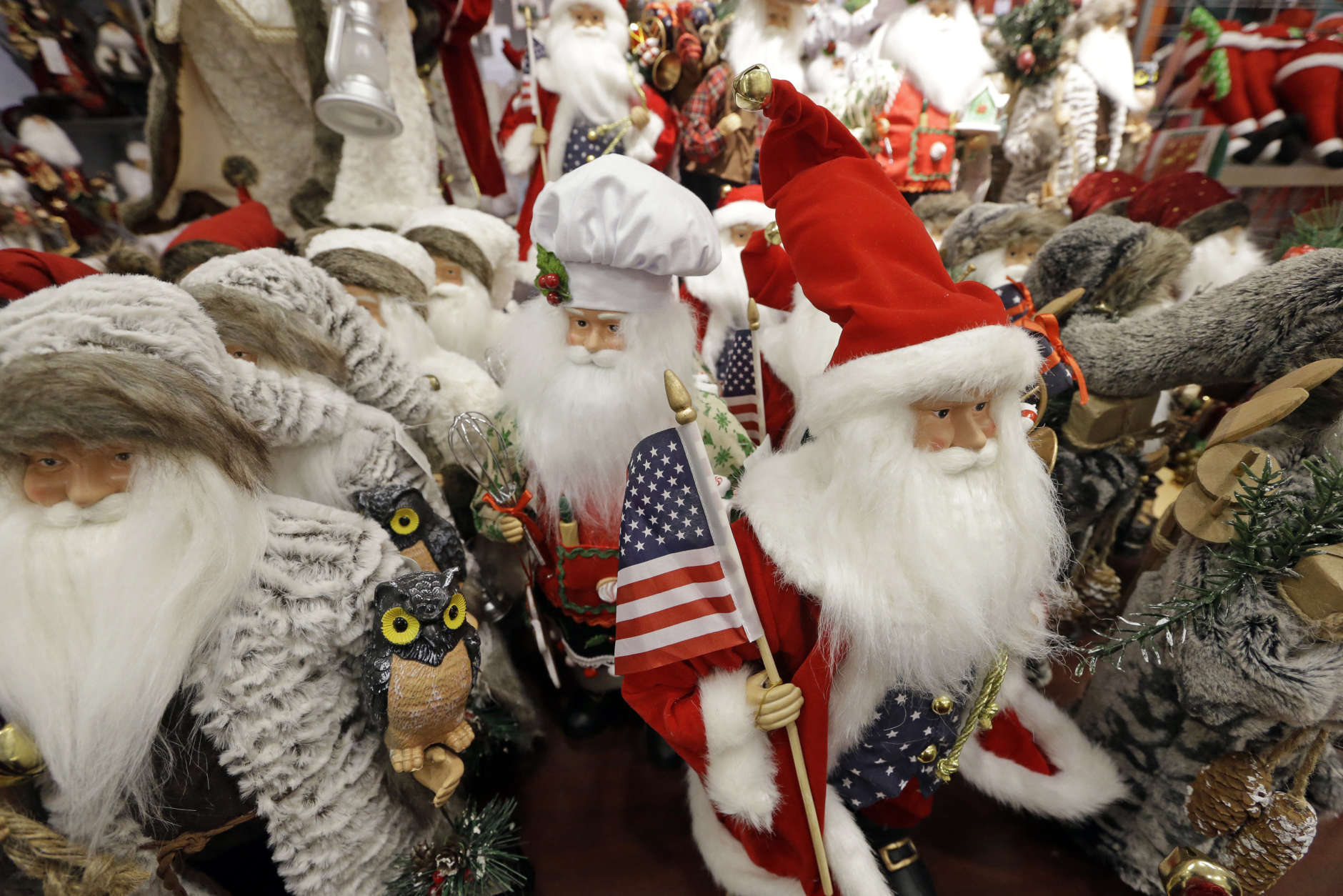 Santa figures, some carrying American flags, are lined-up for sale at a J.C. Penney store, Friday, Nov. 24, 2017, in Seattle. Black Friday has morphed from a single day when people got up early to score doorbusters into a whole season of deals, so shoppers may feel less need to be out. (AP Photo/Elaine Thompson)
