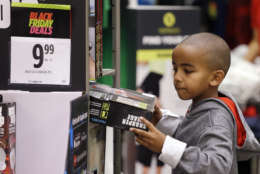 A boy looks over a Black Friday sale item at a J.C. Penney store, Friday, Nov. 24, 2017, in Seattle. Black Friday has morphed from a single day when people got up early to score doorbusters into a whole season of deals, so shoppers may feel less need to be out. (AP Photo/Elaine Thompson)