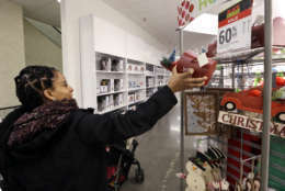 A woman reaches for a Christmas decoration while shopping at a J.C. Penney store, Friday, Nov. 24, 2017, in Seattle. Black Friday has morphed from a single day when people got up early to score doorbusters into a whole season of deals, so shoppers may feel less need to be out. (AP Photo/Elaine Thompson)