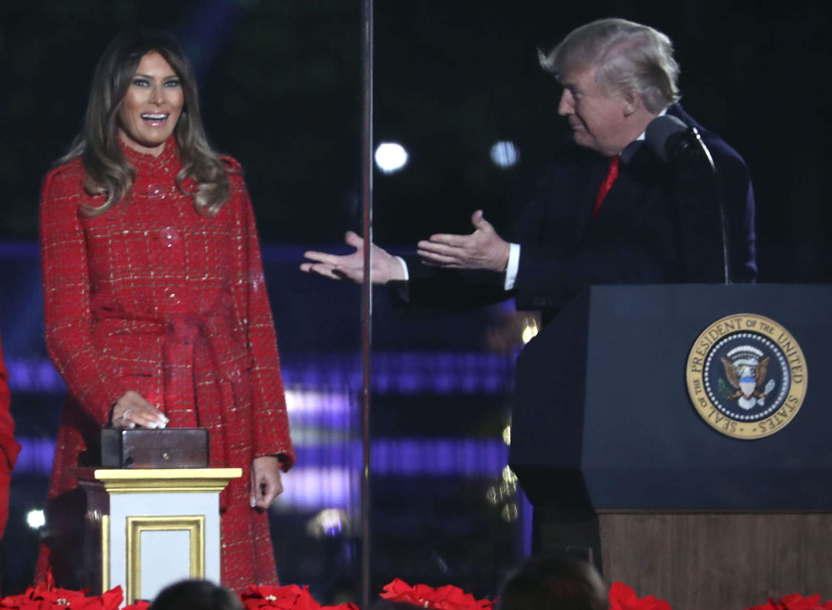 President Donald Trump gestures to first lady Melania Trump to light the 2017 National Christmas Tree on the Ellipse near the White House, Thursday, Nov. 30, 2017, in Washington. (AP Photo/Andrew Harnik)