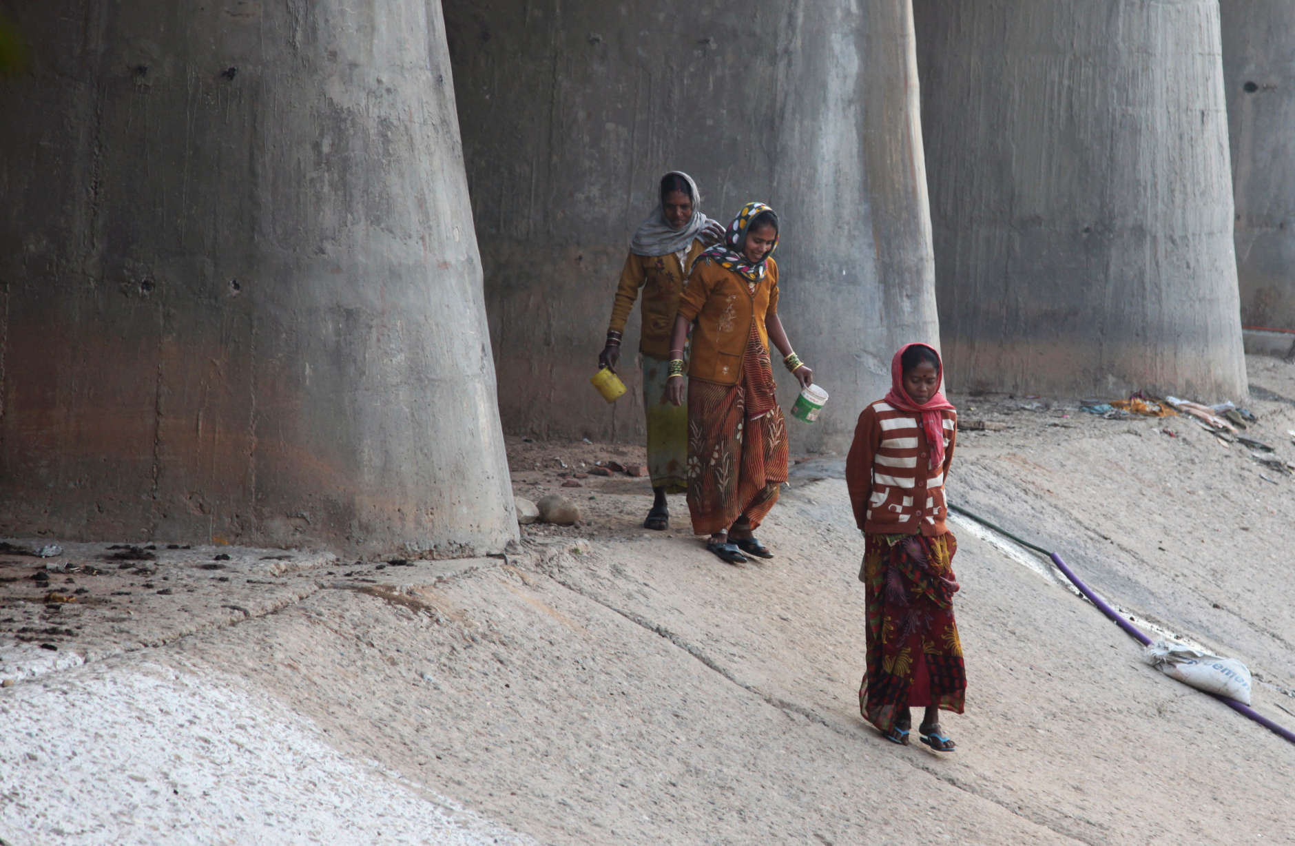 Indian women walk holding tumblers they use to wash themselves after defecating in the open, on World Toilet Day on the outskirts of Jammu, India, Wednesday, Nov. 19, 2014. U.N. figures show of India's 1.2 billion people, 665 million, mostly those in the countryside, don't have access to a private toilet or latrine, something taken for granted in developed nations. Some villages have public bathrooms, but many women avoid using them because they are usually in a state of disrepair and because men often hang around and harass the women. (AP Photo/Channi Anand)