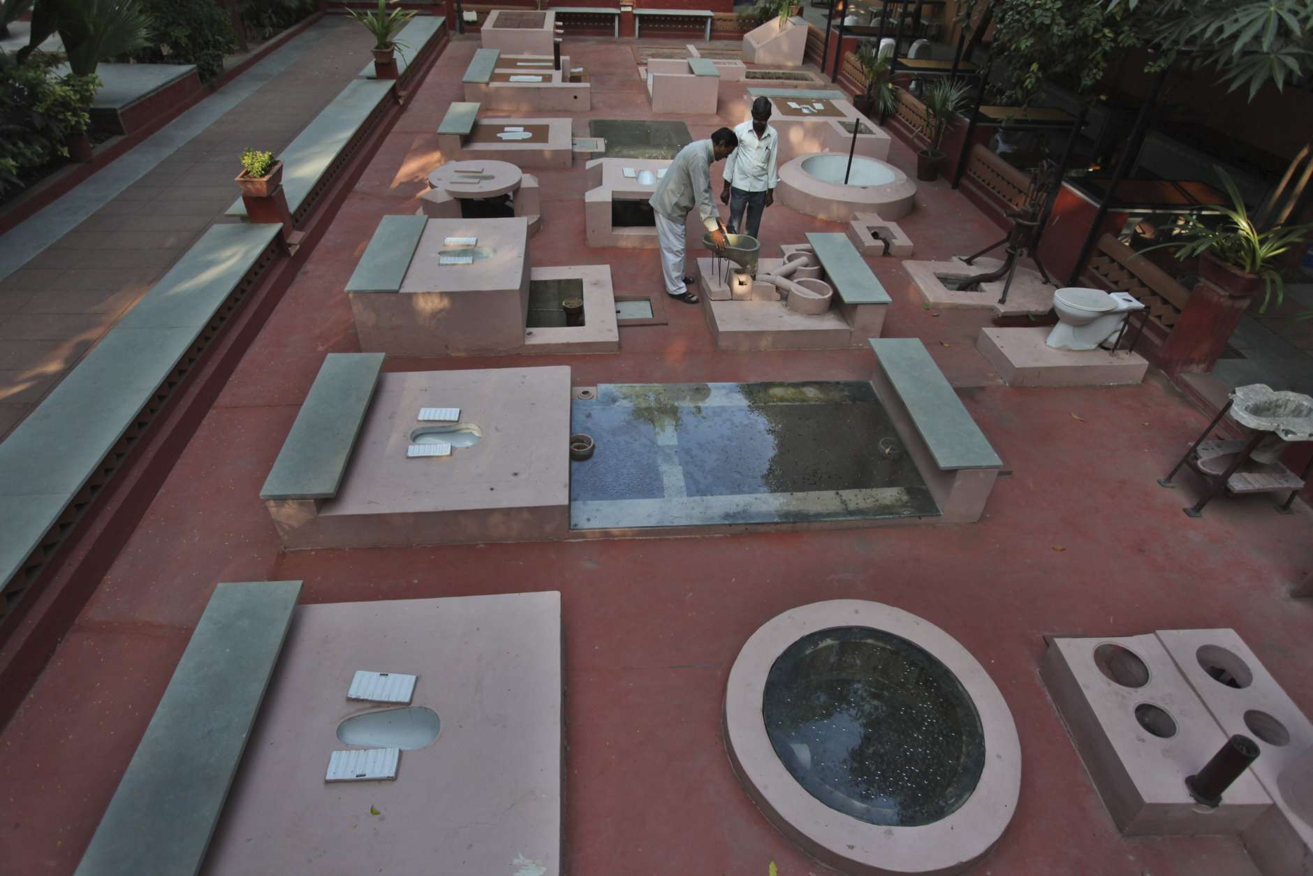 Indians look at the low cost models of toilets that are on permanent display on the premises of the Environmental Sanitation Institute (ESI) on World Toilet Day in Ahmadabad, India, Wednesday, Nov. 19, 2014. India is considered to have the world's worst sanitation record despite spending some $3 billion since 1986 on sanitation programs, according to government figures. Building toilets in rural India, where hundreds of millions are still defecating outdoors, will not be enough to improve public health, according to a study published last month. (AP Photo/Ajit Solanki)