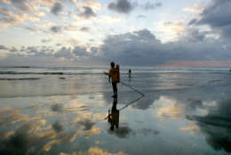 An Indonesian life guard looks out at the sea at the end of the day Tuesday, Oct. 4, 2005 at Kuta beach, Bali, Indonesia. Undeterred by the multiple bomb attacks which killed 22 people three days ago, tourists are back on the beaches in Bali. (AP Photo/Ed Wray)