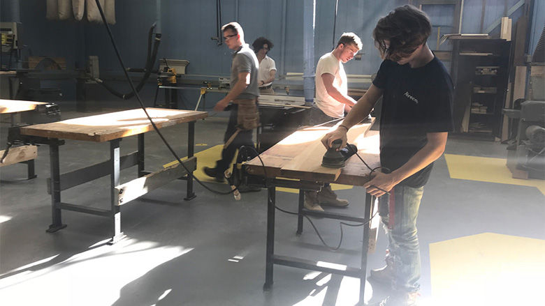 Students in the carpentry program cut and sand down wood to practice constructing small homes in the classroom on Thursday, November 2, 2017. (Georgia Slater/Capital News Service) 