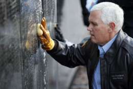 Vice President Mike Pence cleans a portion of the wall at the Vietnam Veterans Memorial on Veterans Day, Saturday, Nov. 11, 2017 in Washington. (AP Photo/Alex Brandon)