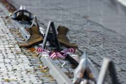 Mementos including a worn pair of boots, have been replaced after the wall was cleaned at the Vietnam Veterans Memorial on Veterans Day, Saturday, Nov. 11, 2017 in Washington. (AP Photo/Alex Brandon)