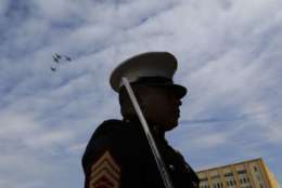 U.S. Marine Staff Sgt. Henry Telon of Miami, Florida, stands at attention as T-38's of the Euro-Nato Joint Pilot Training Wing from Shepard AFB fly over in the missing man formation during a Veterans Day parade in Dallas, Friday, Nov. 10, 2017. (AP Photo/LM Otero)