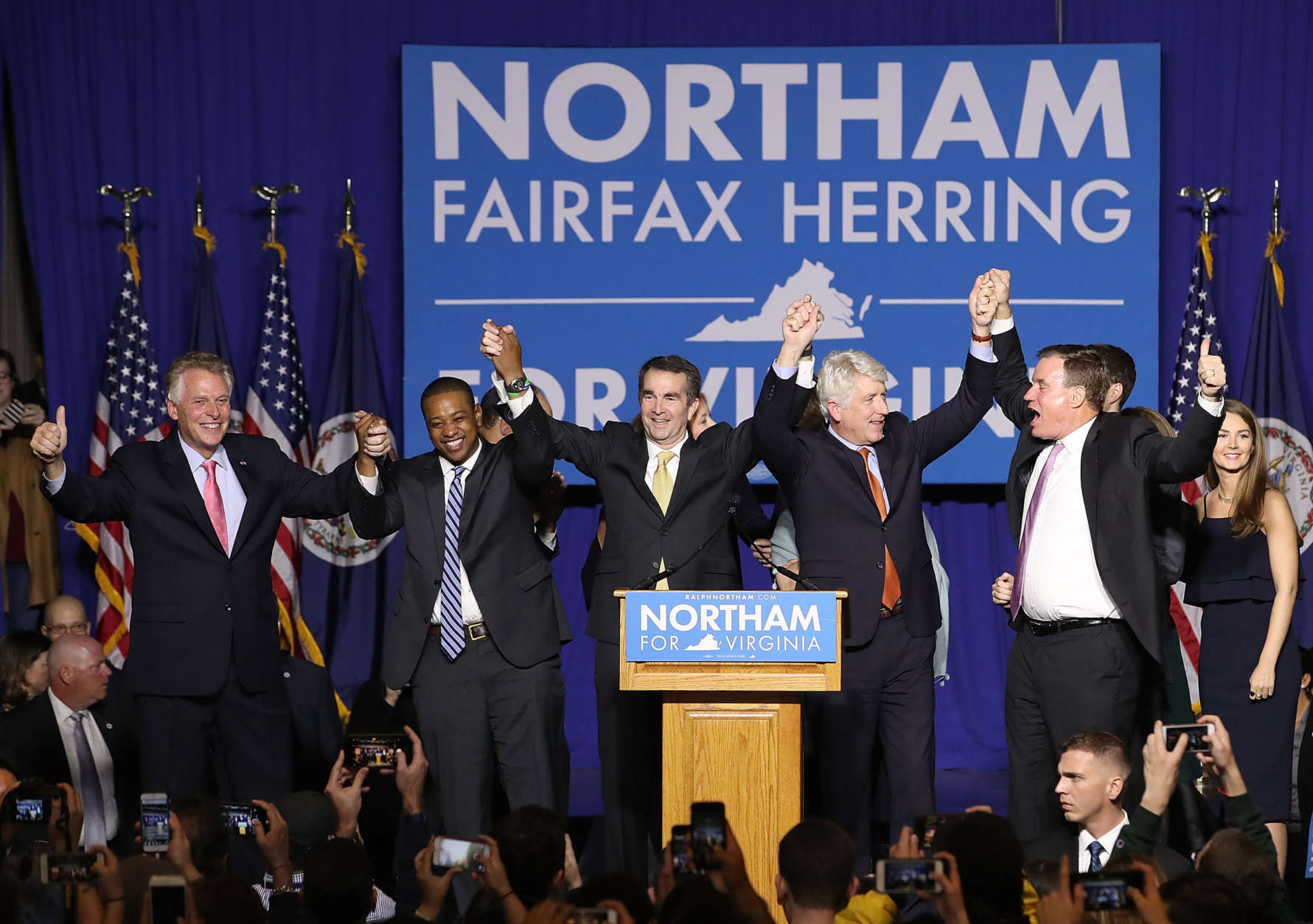 FAIRFAX, VA - NOVEMBER 07:  Gov.-elect Ralph Northam (C) links arms with (L-R) current Gov. Terry McAuliffe, Lt. Gov.-elect Justin Fairfax, Attorney General-elect Mark Herring, and U.S. Sen. Mark Warner (D-VA) at an election night rally November 7, 2017 in Fairfax, Virginia. Northam defeated Republican candidate Ed Gillespie.  (Photo by Win McNamee/Getty Images)